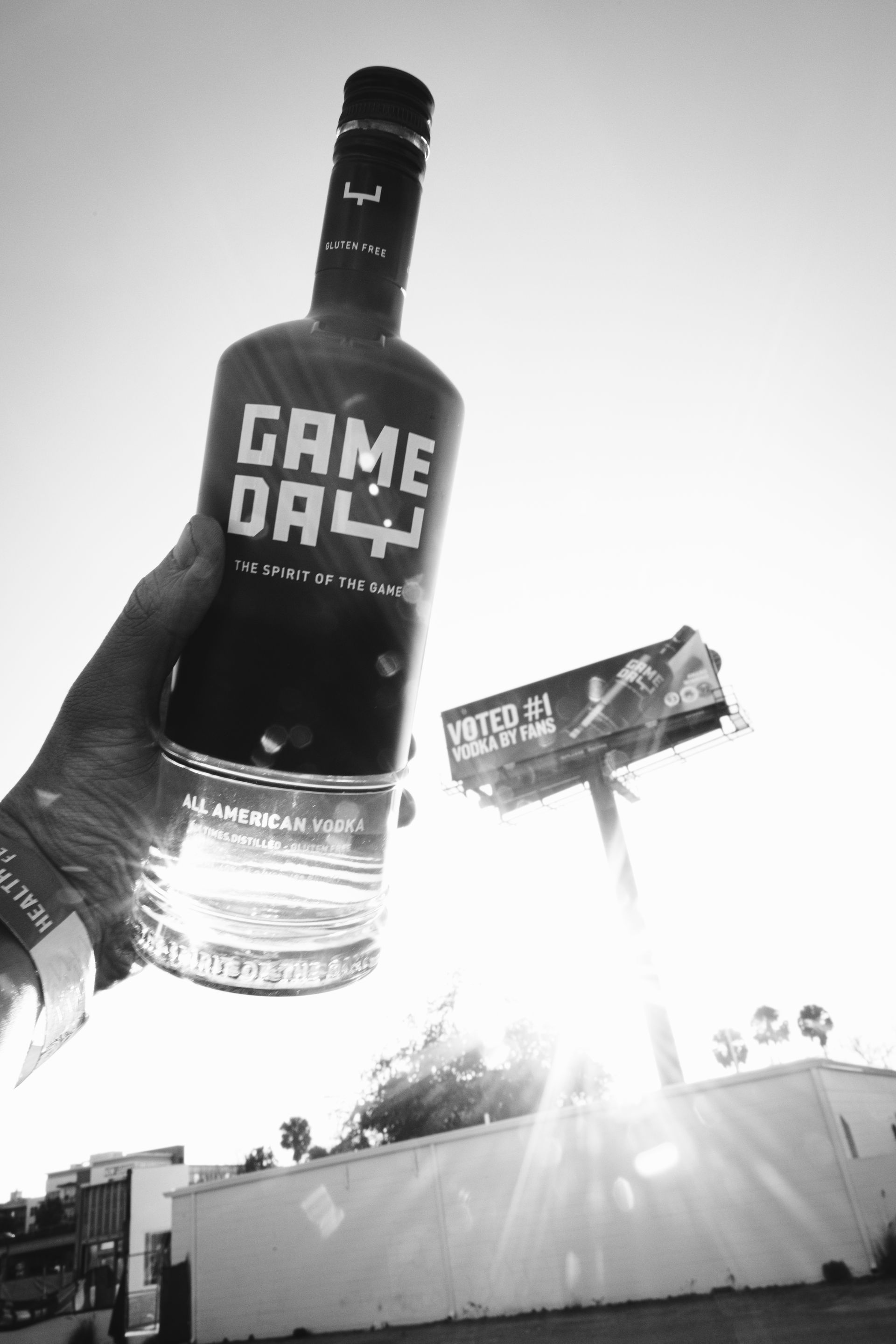 Fans raising GameDay Vodka cocktails together at a tailgate