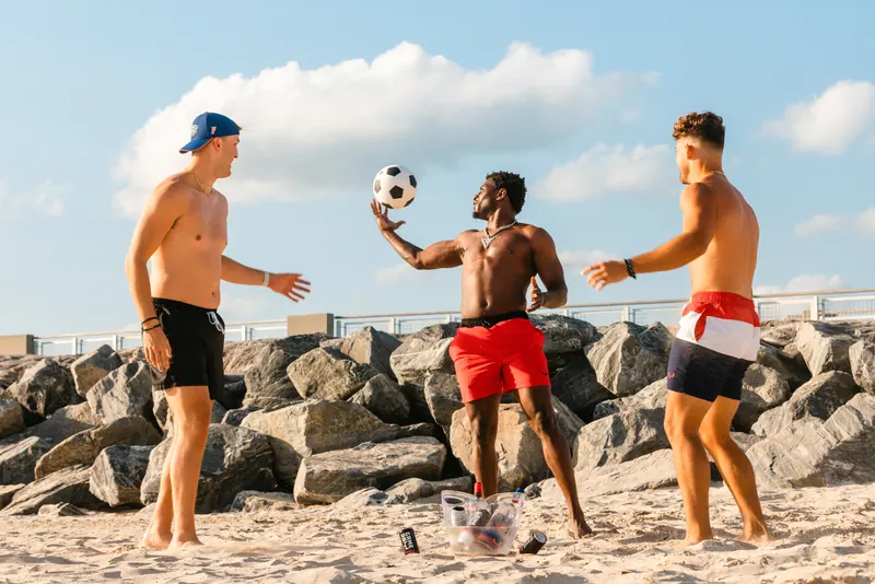 Throwing a football across the rocks with GameDay Spiked cans nearby